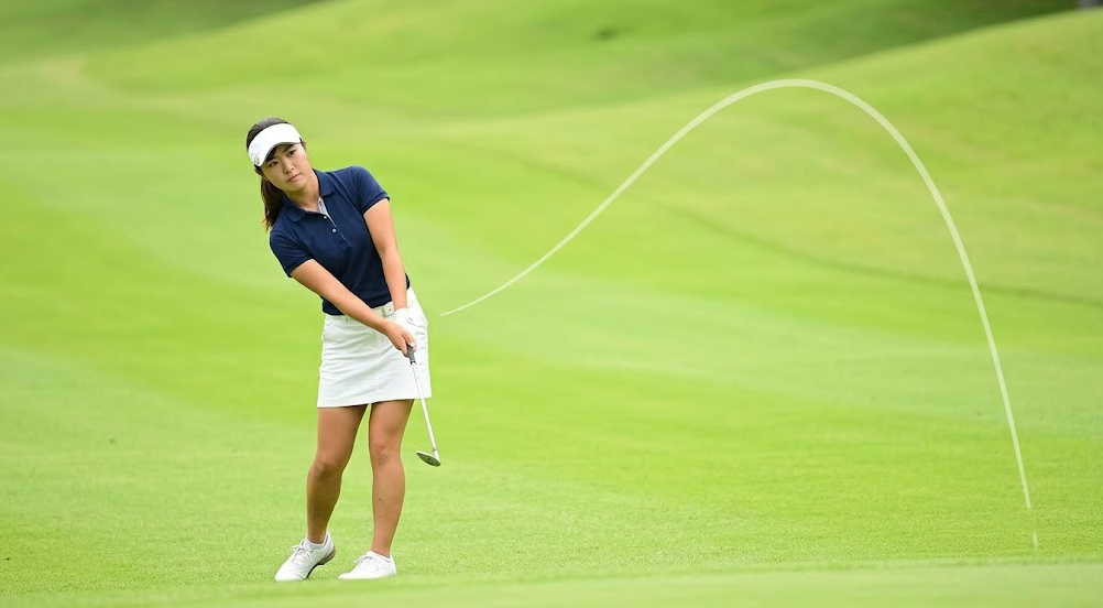 アプローチウェッジで一定のリズムでスイングする日本人女性アマチュアゴルファー
